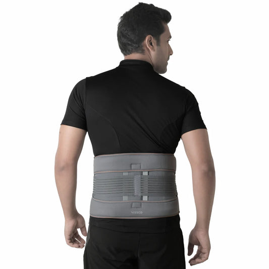 Man wearing a gray back brace on a white background