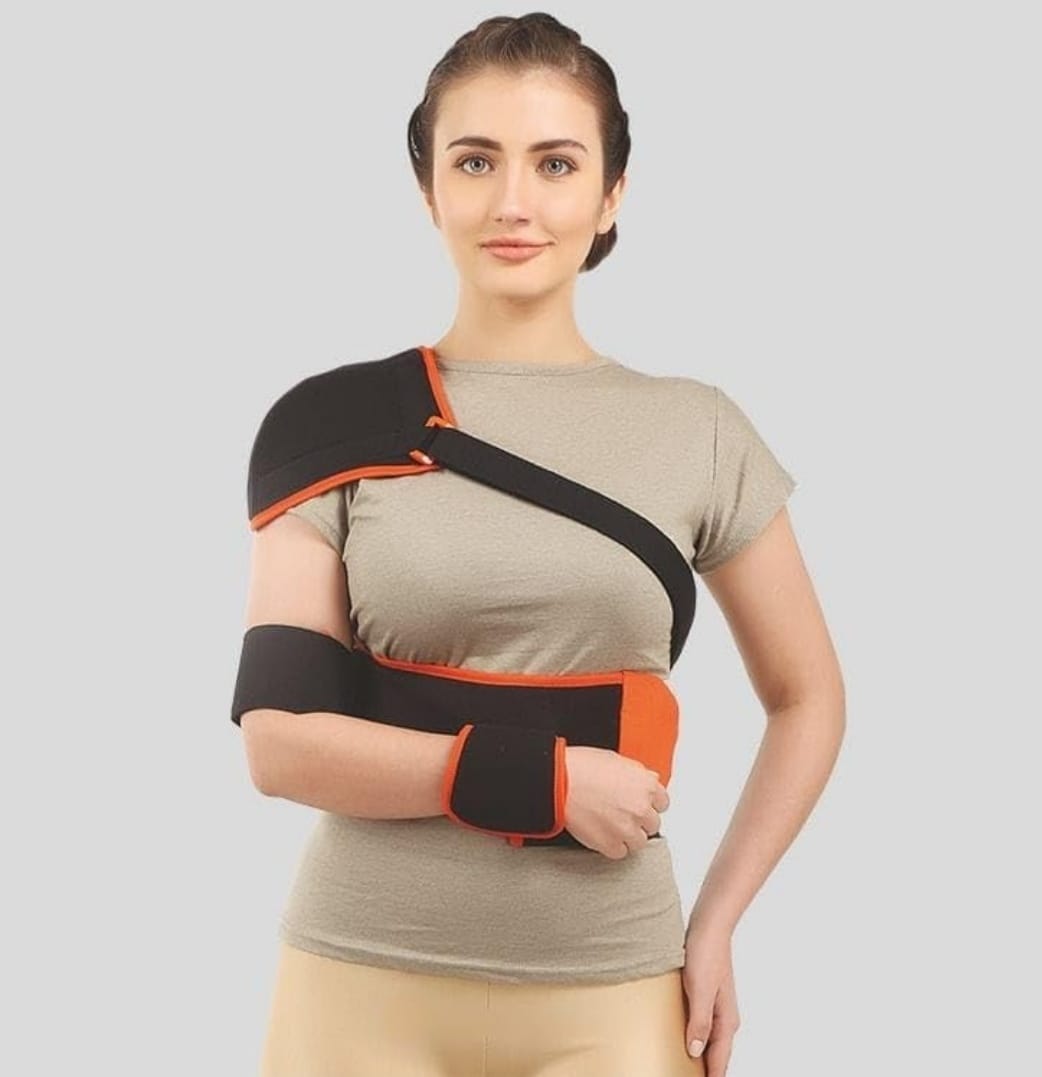 Woman wearing a black and orange arm brace on a gray background